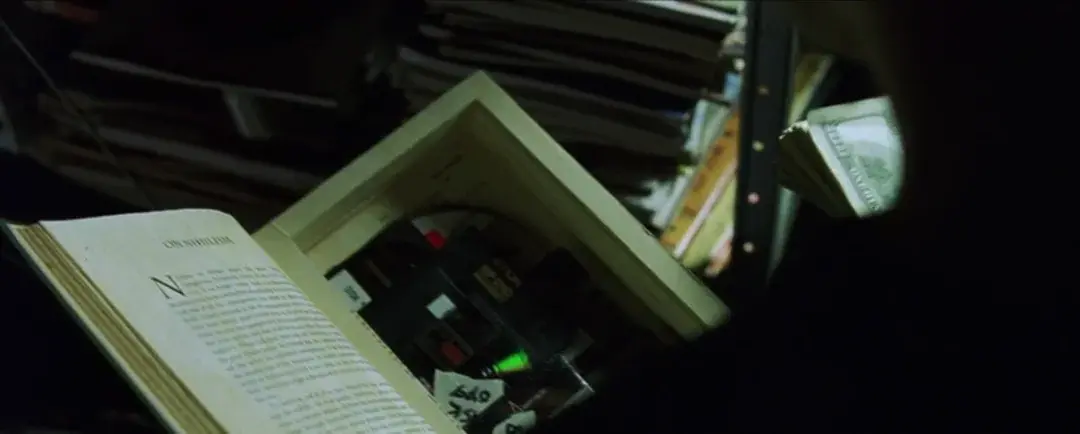Neo hides stuff in a hollowed-out copy of the book